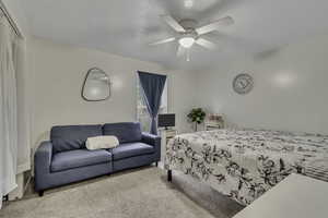 Carpeted bedroom featuring a ceiling fan