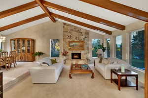 Spacious living room featuring beamed vaulted ceiling, plenty of natural light