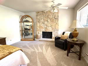 Newly carpeted MSTR Bedroom featuring crown molding, light colored carpet, a fireplace, and ceiling fan