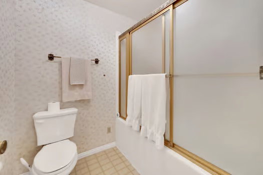 Full bathroom with enclosed tub / shower combo.