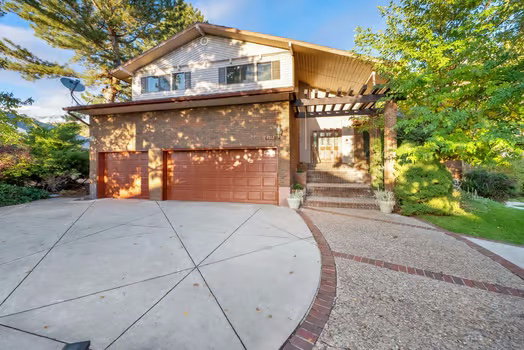 View of front of home with driveway, brick siding, and an attached garage