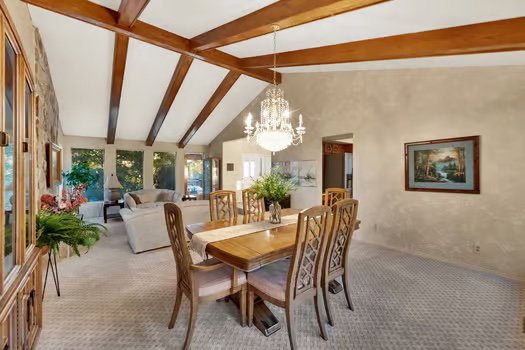 Elegant dining room with designer carpeting and vintage chandelier. Many gorgeous new windows with lots of natural light!