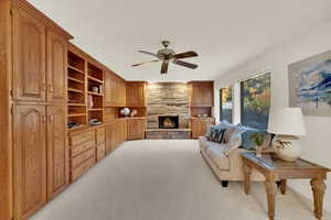 Family Room section of large open Great Room featuring custom wood cabinets & fireplace and lots of windows with  fantastic back-yard view