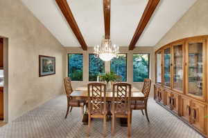 Dining room featuring large open window chandelier, lots of light & beautiful view into lush backyard.