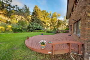 Large deck with built-in seating and beautiful yard.