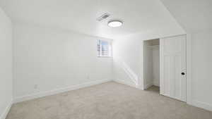 Unfurnished bedroom with a textured ceiling, a closet, and light carpet