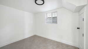 Bonus room featuring carpet flooring and a textured ceiling