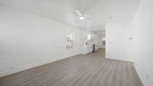 Unfurnished living room featuring light wood-style flooring and a ceiling fan