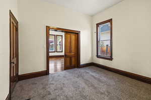 Carpeted spare room featuring a textured wall