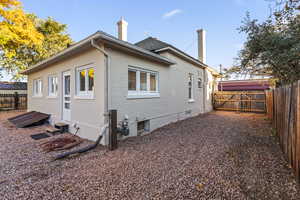 View of side of home featuring a fenced backyard, a chimney, and brick siding