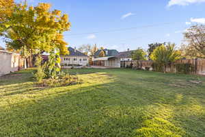 Fenced backyard featuring a carport