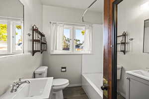 Bathroom with vanity, shower / bath combo, and wood finish floors