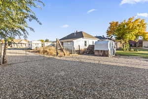 View of front facade with a gate and a storage shed