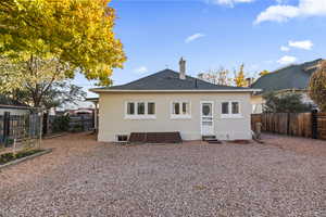 Rear view of property featuring a fenced backyard and a shingled roof