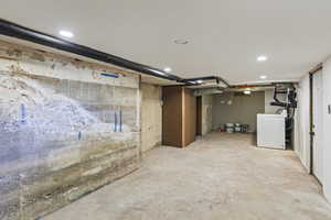Unfinished basement with washer / clothes dryer and recessed lighting
