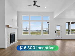 Unfurnished living room with a fireplace, plenty of natural light, wood finished floors, and recessed lighting