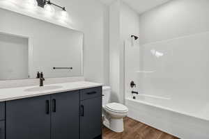 Full bathroom featuring dark wood-style flooring, shower / bathtub combination, and vanity