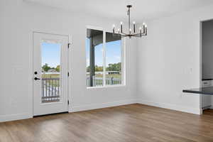 Unfurnished dining area with light wood finished floors and a chandelier