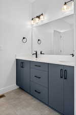 Bathroom with double vanity and light tile patterned floors