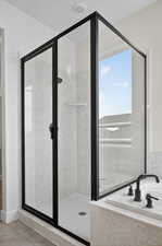 Bathroom featuring a marble finish shower, a bath, and light tile patterned floors