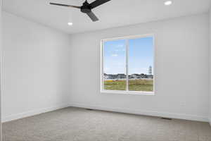 Spare room with light colored carpet, recessed lighting, ceiling fan, and a residential view