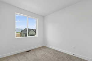 Carpeted empty room with baseboards and a mountain view
