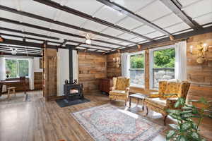 Great Room with a wood stove, large windows, and a ceiling fan.