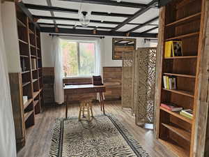 Library with bookshelves and a wainscoted wall. Staged with a room divider.