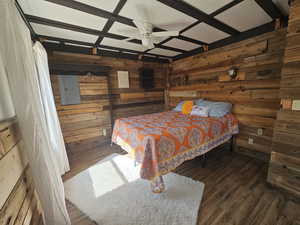 Bedroom featuring wood walls, a window, and ceiling fan.