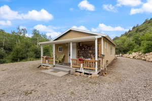 View of front of home with gravel driveway and a porch.