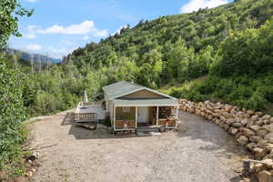 Front of property featuring a forest view, a mountain view, and a porch.