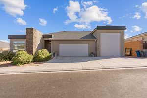 View of front of home featuring an attached garage, stucco siding, and concrete driveway