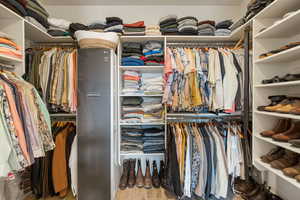 Walk in closet with light wood finished floors