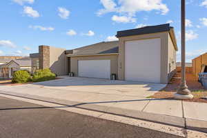 View of front of property with stucco siding, a garage, and concrete driveway