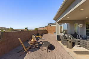 Fenced backyard with a fire pit and a patio