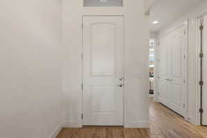 Entrance foyer with light wood finished floors and recessed lighting