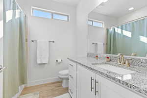 Bathroom with vanity, light wood-style floors, and curtained shower