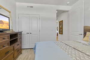 Bedroom with light wood-type flooring and a closet