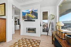 Living area with light wood finished floors, recessed lighting, and a lit fireplace