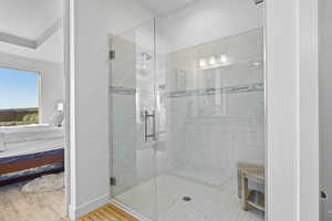 Ensuite bathroom featuring a shower stall and wood finished floors
