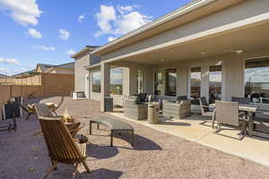 View of patio featuring french doors, an outdoor living / dining area, and a fire pit
