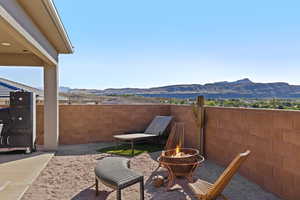 Fenced backyard with a mountain view, a patio area, and a fire pit