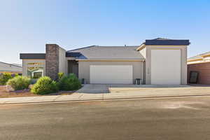 View of front of home with a garage, stucco siding, and driveway
