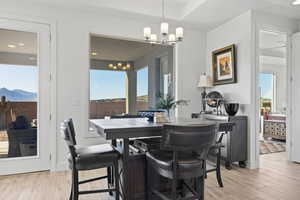 Dining space featuring light wood-style flooring, healthy amount of natural light, a chandelier, and recessed lighting