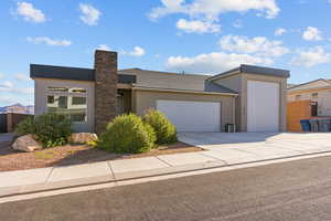 Contemporary house with an attached garage, stucco siding, and driveway