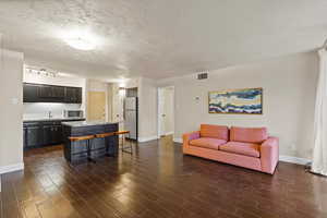 Living area with a textured ceiling and dark wood finished floors