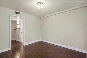 Unfurnished bedroom featuring a textured ceiling and dark wood-style flooring