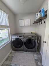 Laundry area with stone finish flooring and washer and clothes dryer