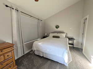 Bedroom featuring lofted ceiling and carpet flooring