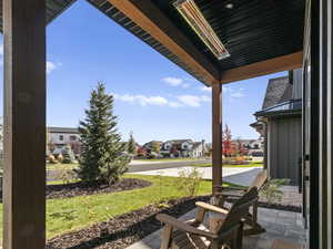 Covered porch with a residential view and a yard